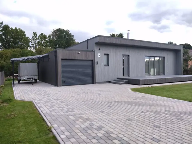 Koka māja ar garāžu, nojumi un bruģētu iebrauktuvi